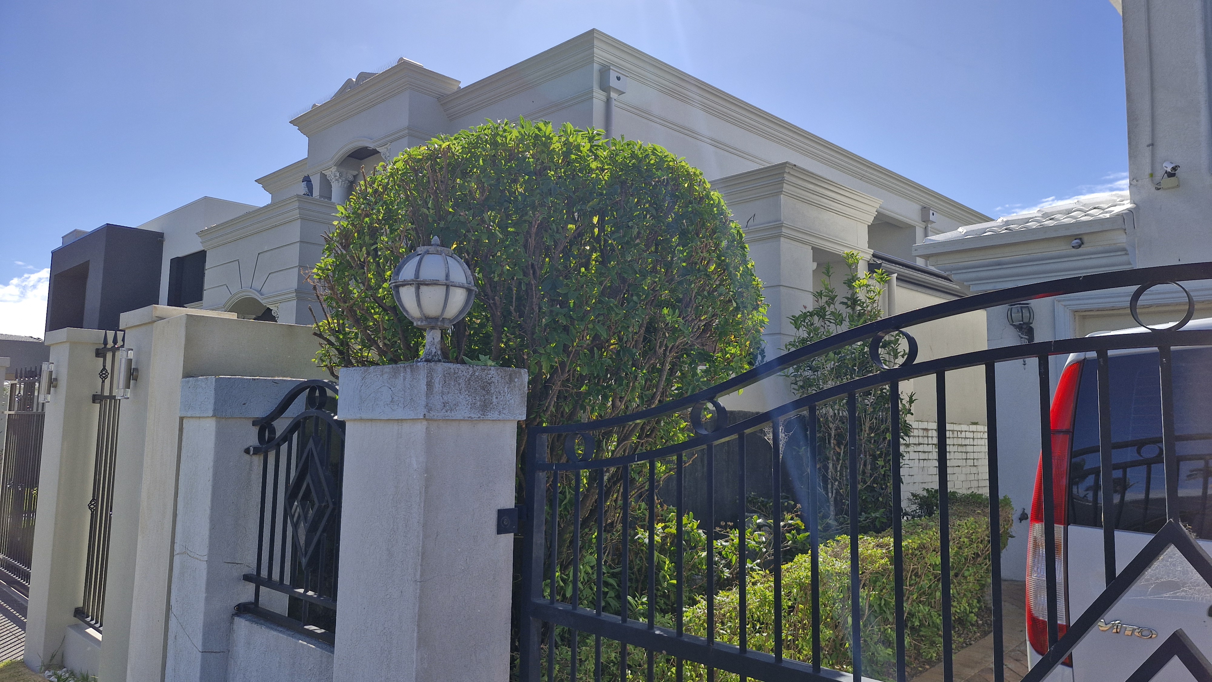 Shaped topiary ball at gated entrance of a luxury home