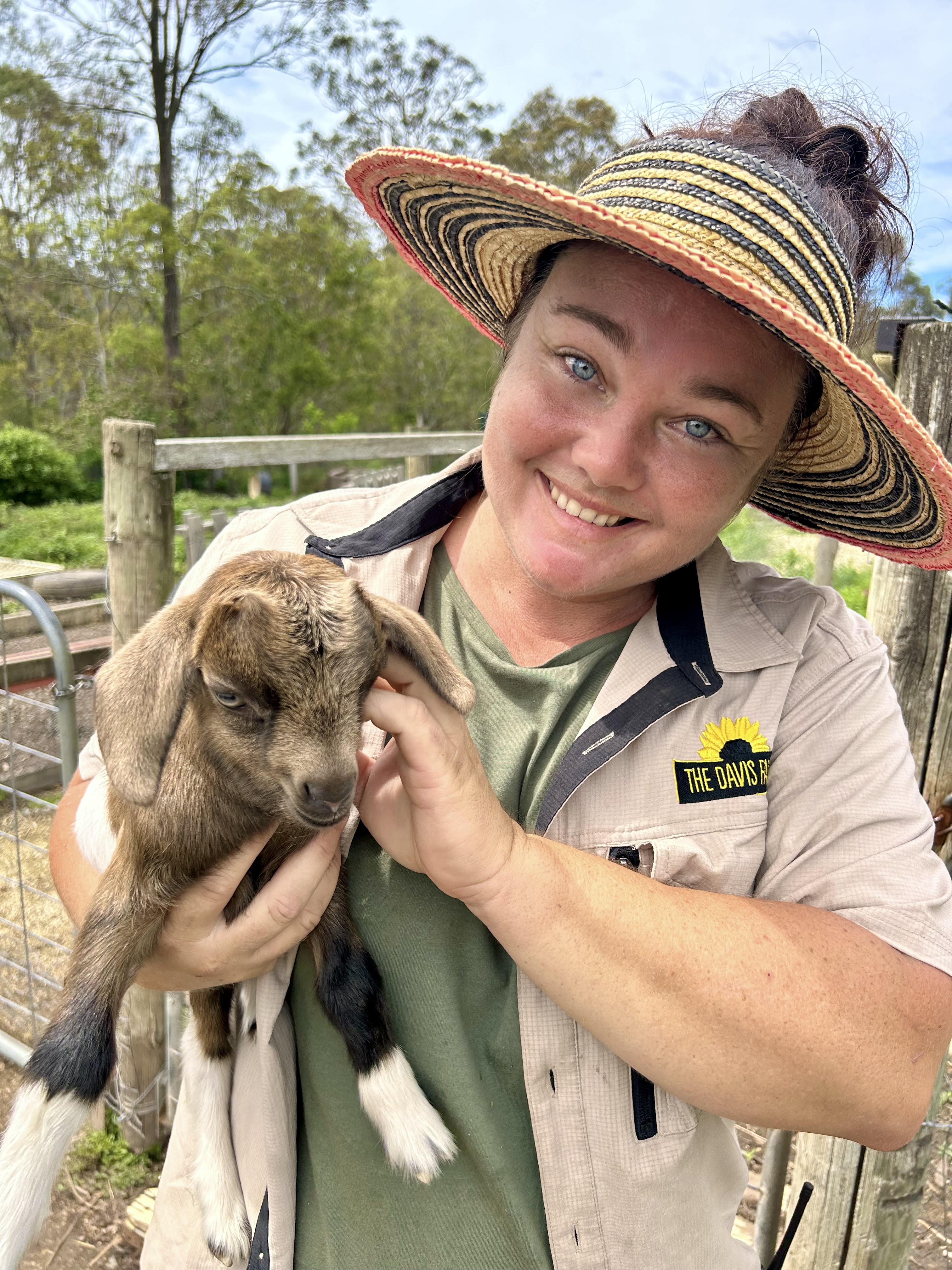 Aj with a baby goat at The Davis Farm