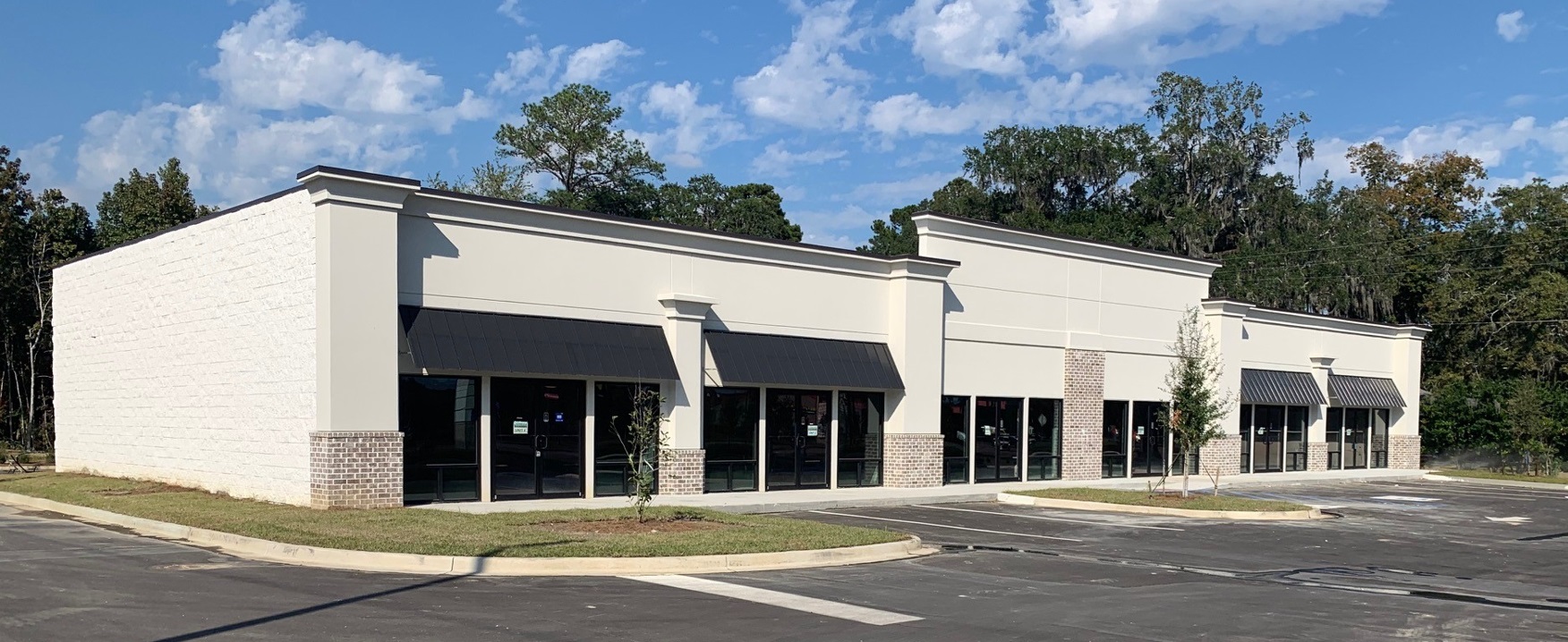 Single-storey retail building with rendered and masonry walls and awnings over shopfronts