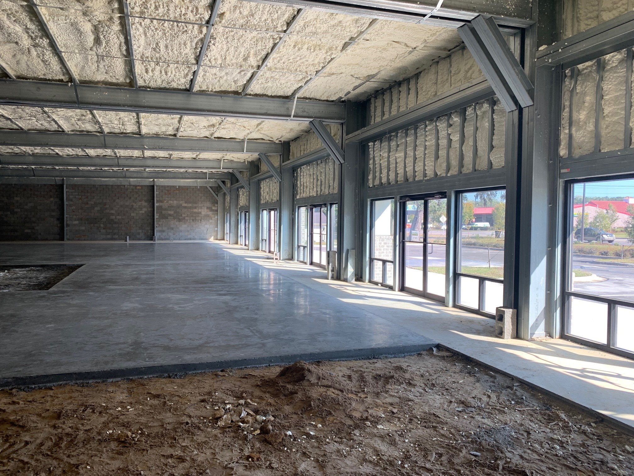 Interior of a cold-formed steel frame commercial building with spray foam insulation on the roof and walls