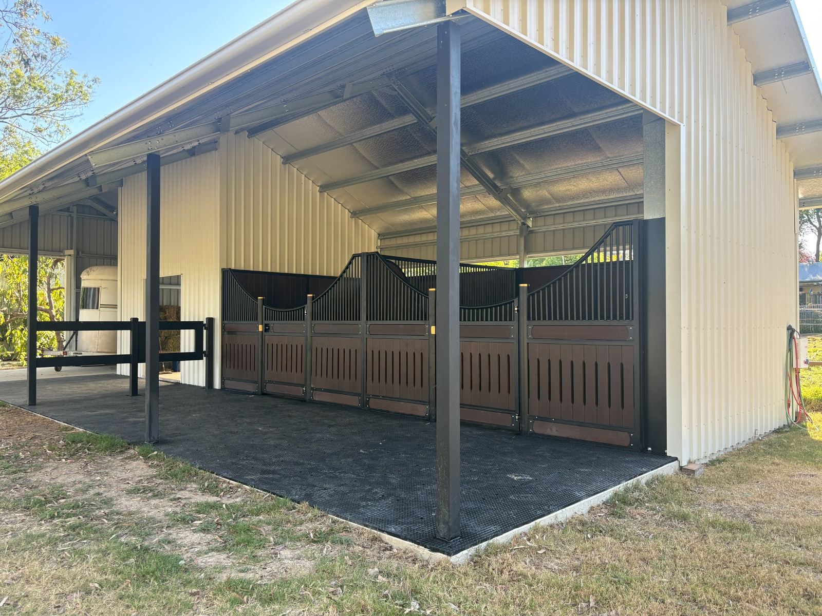 Steel equestrian shed with covered stables, timber-look stall fronts and rubber flooring