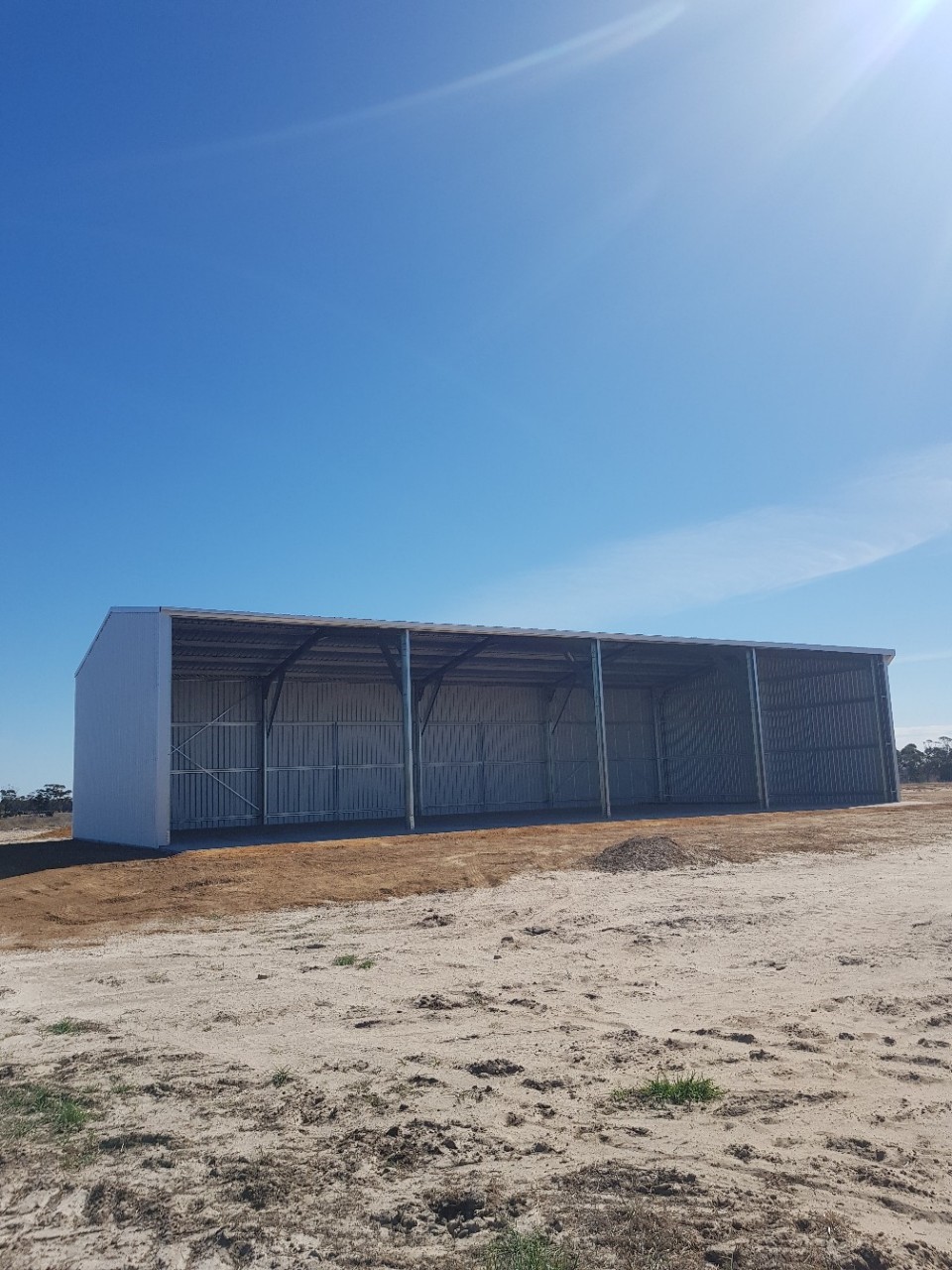 Large open-front steel hay shed with wide bays