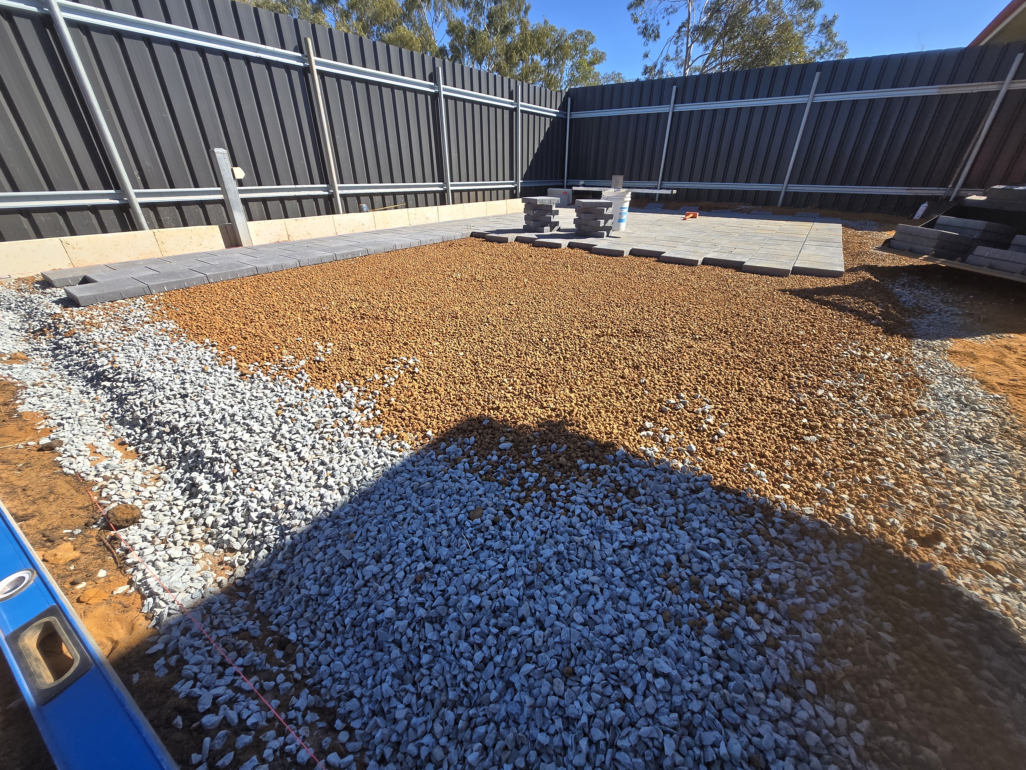 Recent paving job in Kalgoorlie: site preparation with crushed rock base and Colourbond fencing