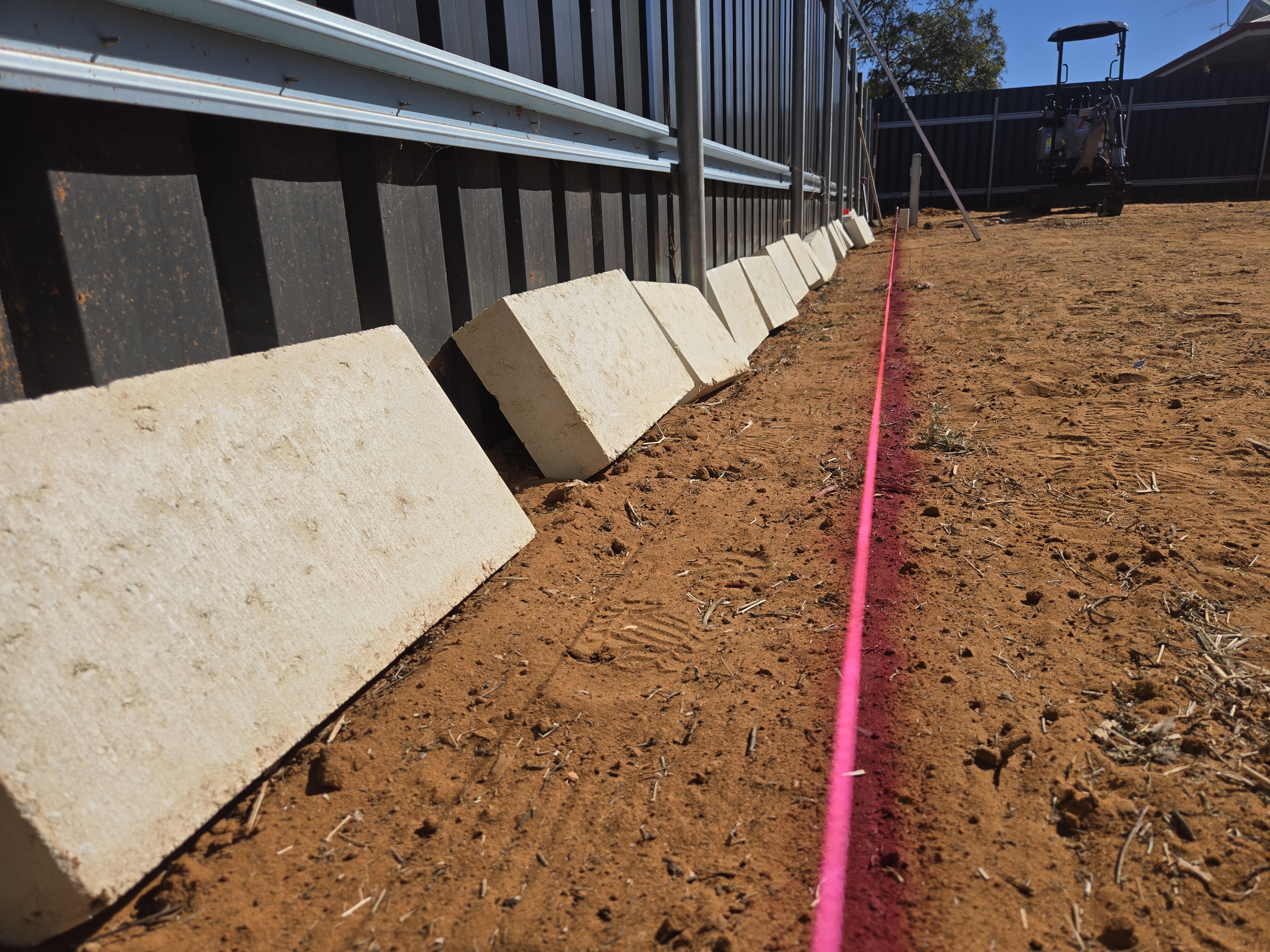Recent retaining wall job in Kalgoorlie: limestone blocks lined up with string line for precision installation