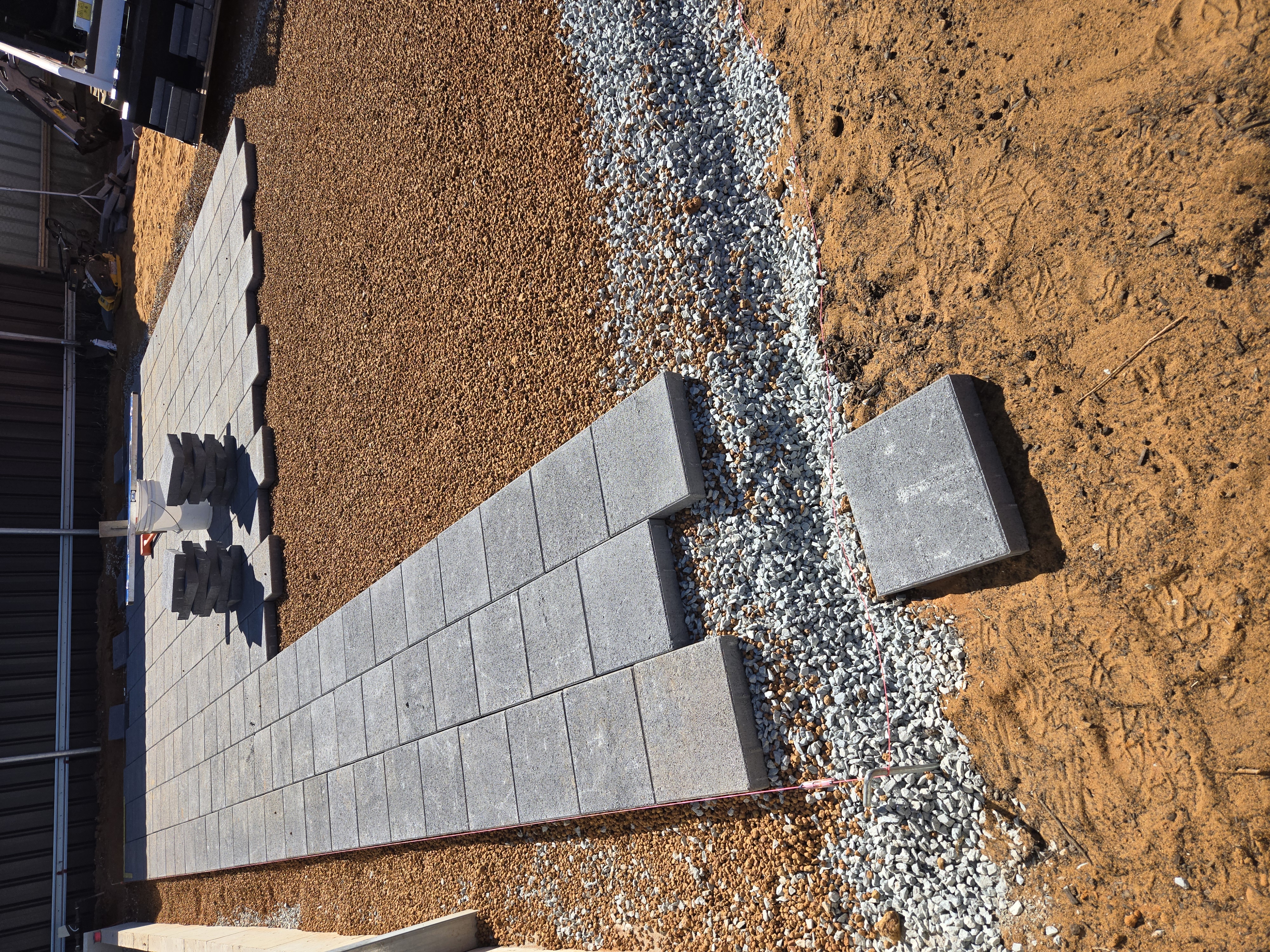 Recent paving job in Kalgoorlie: paver patio installation in progress with base preparation and Colourbond fencing