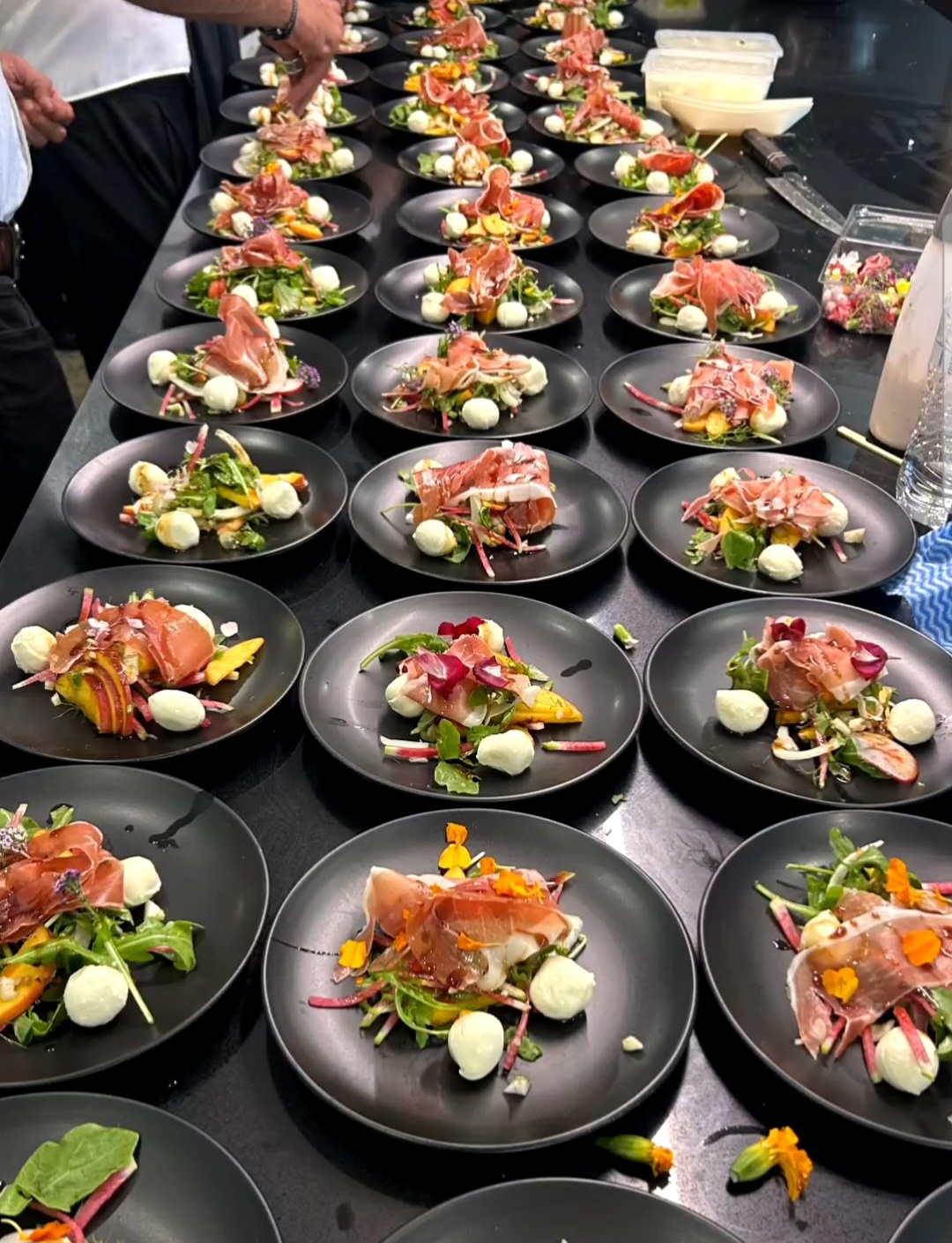 Mass plating of prosciutto mozzarella salads for a catered event