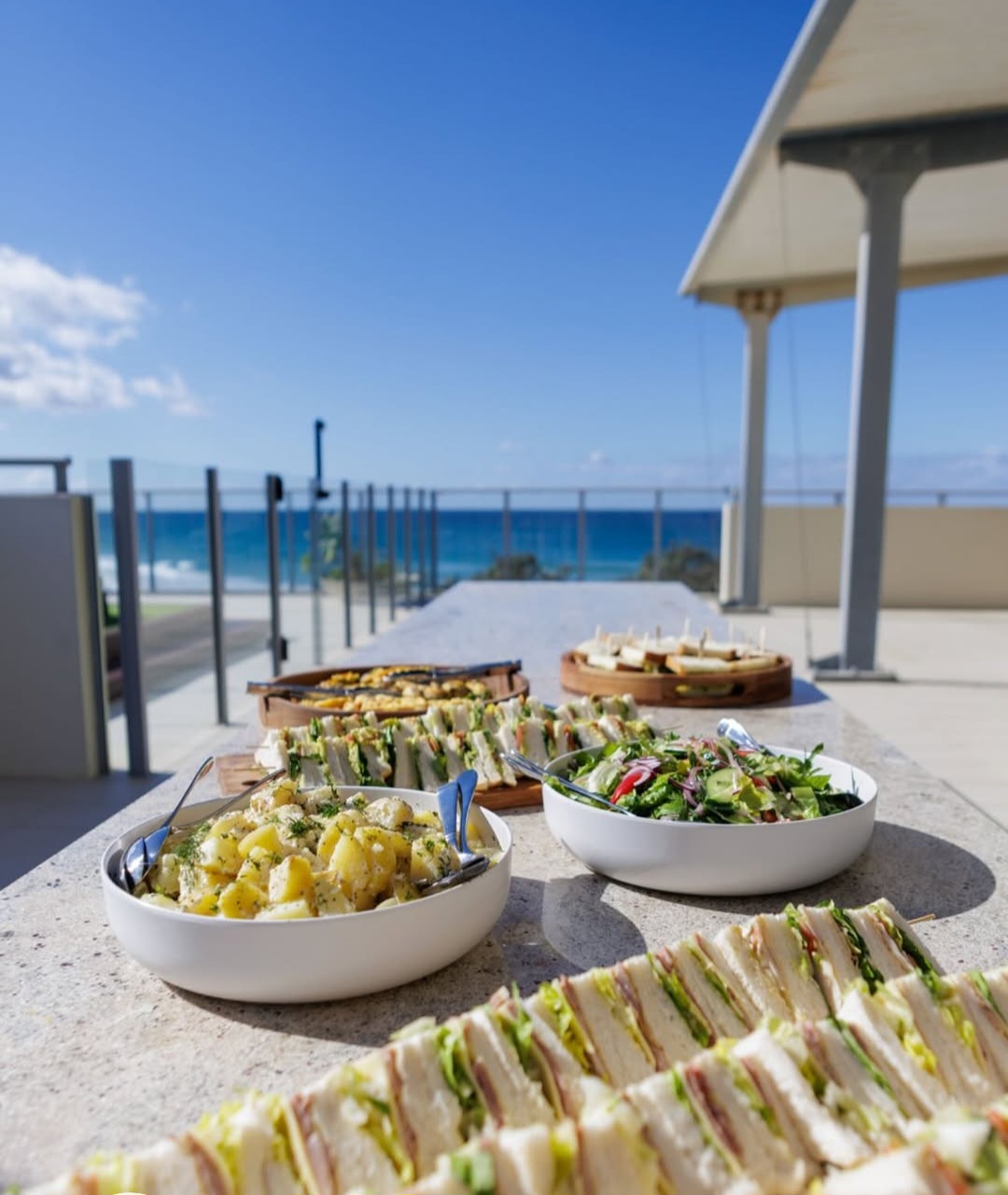 Beachside luncheon spread with sandwiches and ocean views