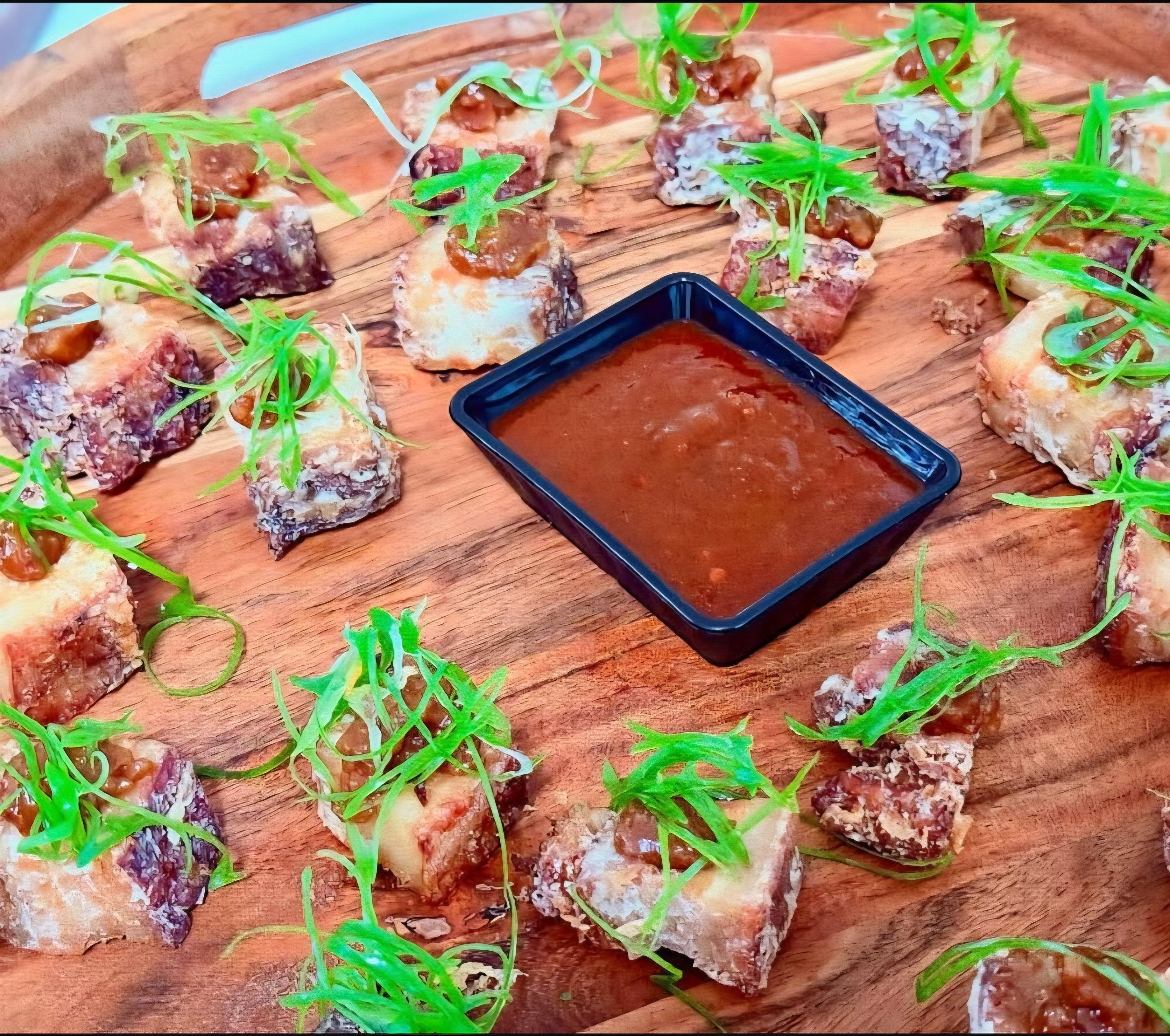 Crispy pork belly bites with house sauce and spring onion