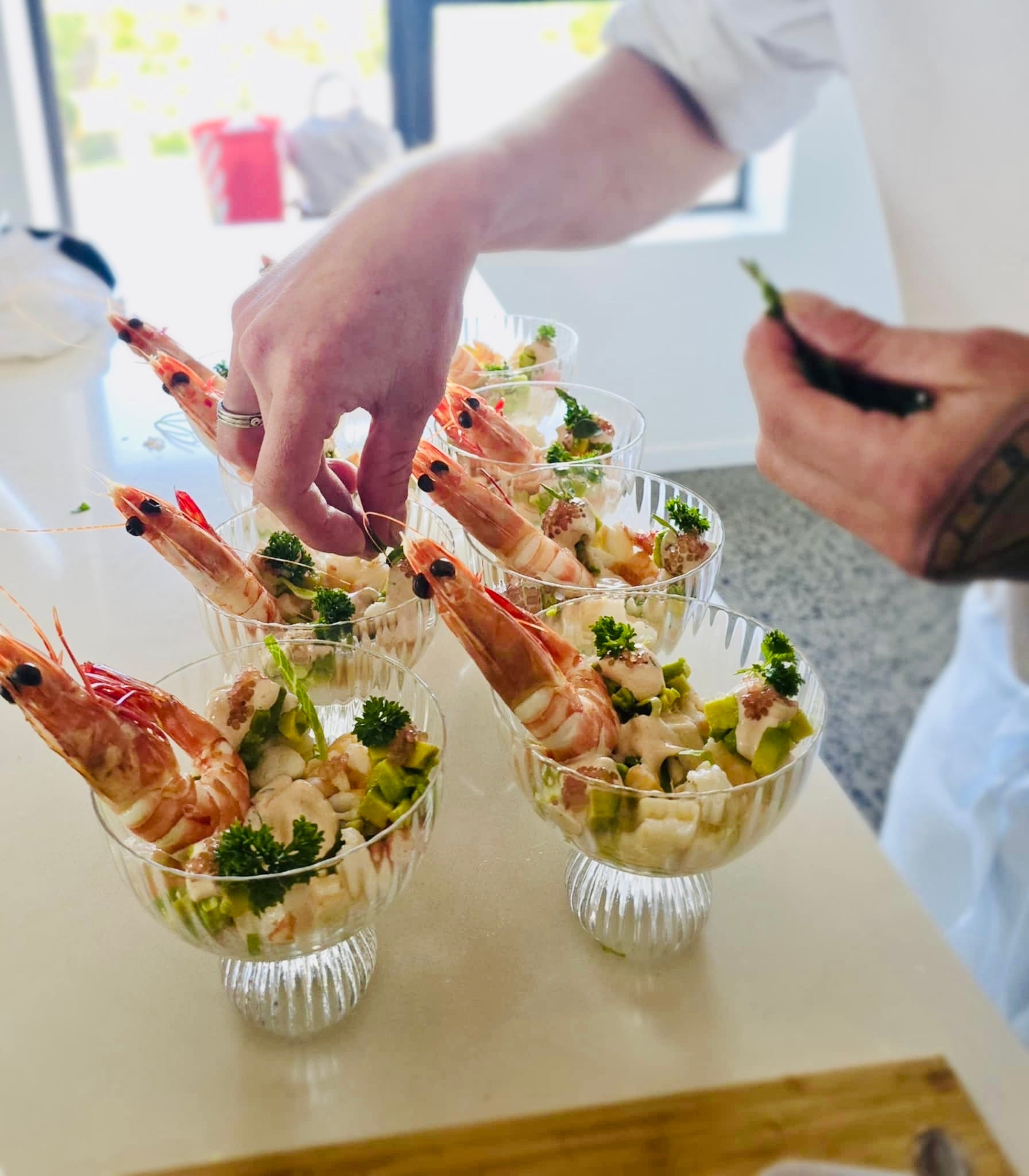 Prawn cocktails being plated in crystal glasses