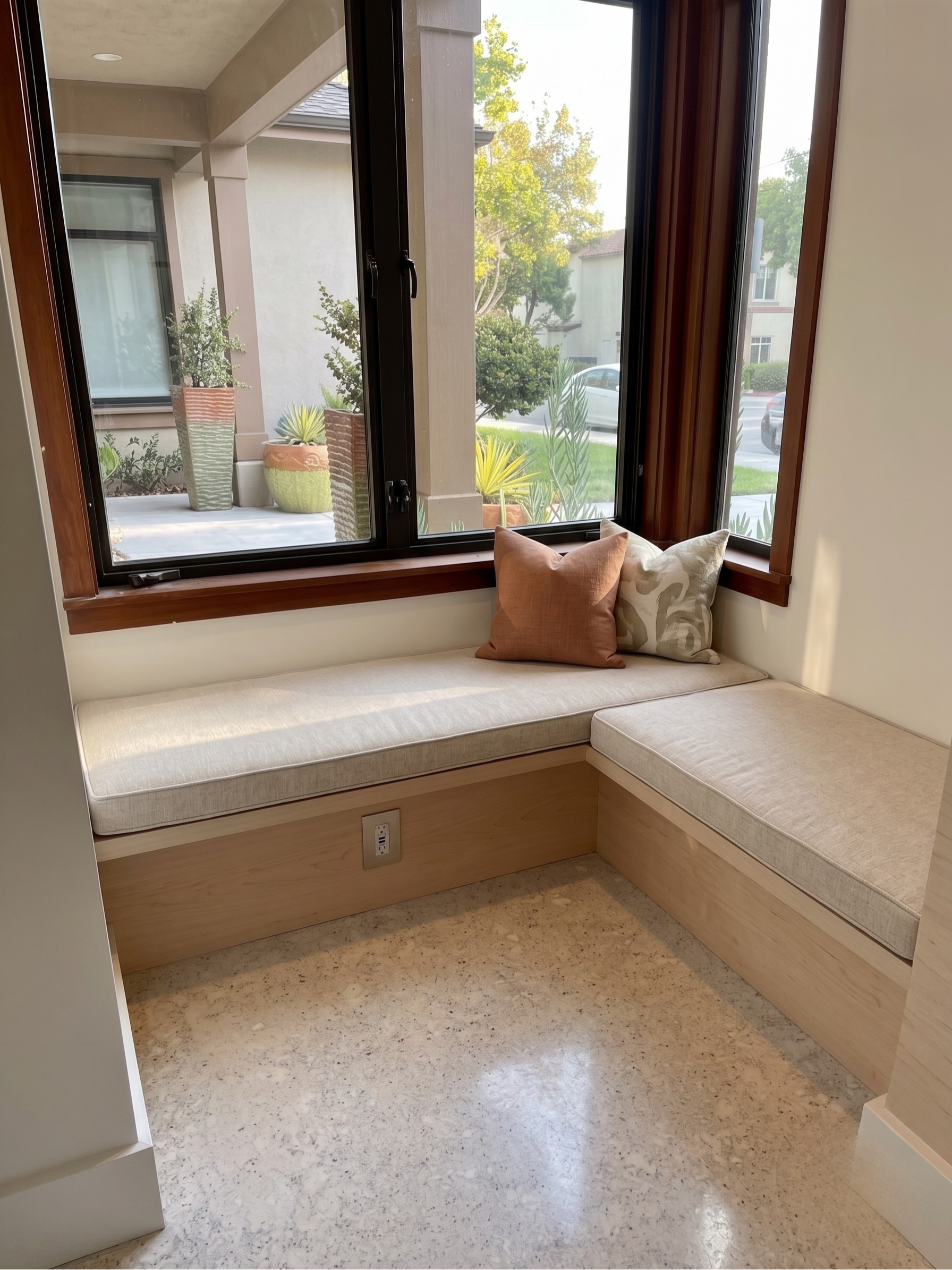 Custom built-in seating nook with light tone maple wood veneer and architectural millwork for apartment complex common area seating area in Goleta CA