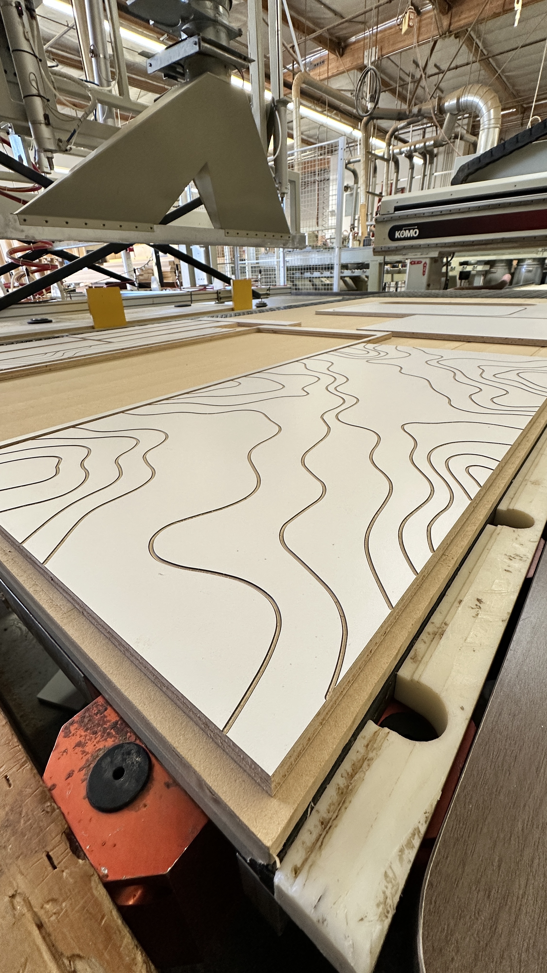 CNC precision decorative routing — custom wave pattern cut into melamine panels